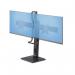 The photo shows a sleek, modern desk stand with a crossbar design, capable of holding two 27 inch monitors side by side. The monitors are mounted on individual arms, providing flexible positioning options. The stand is sturdy and suitable for any office or workspace setup.