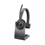 This image shows a black HP Poly wireless headset, the Voyager 4320-M UC, in its stand. The headset has a sleek, modern design with comfortable padded ear cups and a flexible microphone. The USB-A connectivity allows for easy use with devices.