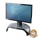 This photo shows a damaged box containing Fellowes Monitor Stands & Dust Covers, specifically the 8020101 Smart Suites Monitor Riser and 35474J models. The stands and covers appear to be in good condition despite the damaged packaging. The riser is designed to elevate and organize your monitor for a more comfortable and efficient workspace.