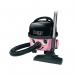 A photograph of the Numatic Hetty Vacuum Cleaner showcases a vibrant pink hue with a sleek and compact design. The Numatic logo is prominently displayed on the front along with the on/off switch and handle for easy maneuverability. The transparent dust bin and replaceable vacuum bags can also be seen, making cleaning a breeze.