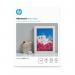 The image shows a pack of glossy white photo paper by HP, measuring 13x18cm, with a total of 25 sheets inside. The paper is advanced and high quality, perfect for printing vibrant and sharp photographs.