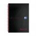 The photograph captures a set of Black n Red wirebound notebooks in A5 size. The notebooks have a hardback cover and are ruled with perforated pages for easy tearing. The deep red and black color scheme exudes a professional and timeless elegance.