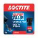 The photograph features a small plastic bottle with a red cap and a label that reads Henkel Super Glue Loctite Original Brush On. The bottle contains 5 grams of glue and is sitting on a flat surface. The label also includes a small brush attached to the cap.