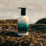 The image is of a 300ml bottle with a label of The Scottish Fine Soaps Company Hand and Body Lotion Sea Kelp Moisturiser. The bottle is surrounded by 6 other identical bottles, all new with tags. The lotion appears to have a light blue color and the design on the label features kelp leaves.