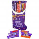 The image shows a festive, red and gold stocking filled with a selection of Cadbury chocolate bars, such as Dairy Milk, Twirl, Flake, and Dairy Milk Oreo. The stocking is surrounded by sparkles and snowflakes, making it the perfect holiday treat or gift.