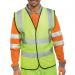 A group of bright yellow high visibility vests hang on a rack, marking their size with XL. Their reflective strips and Beeswift logo catch the light, while the WCENGXL tag hangs from the larger vest.