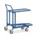 In the photograph, there are several slingsby platform trucks and Fetra warehouse trolleys lined up in a warehouse setting. The trucks have sturdy metal frames and large wheels for easy transport. Some are loaded with boxes and crates, while others are empty and ready to be used. The trolleys have shelves and handles, and appear to be well-built and versatile for various tasks. The overall image conveys functionality and practicality in the industrial setting.