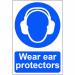 The photo captures a bright yellow sign with bold black text reading Wear ear protectors - 1.2mm Recyclable PP against a white background. The sign is 200 x 300mm in size and features the Spectrum Industrial branding. A person wearing ear protectors is also shown on the sign, emphasizing the message.