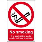 This photograph shows a Spectrum Industrial No Smoking Sign, made of self-adhesive vinyl and measuring 148mm x 210mm. The sign prominently displays the message No Smoking, with the additional statement It Is Against The Law To Smoke On These Premises. The sign features a simple and clear design, with bold text and a red and white color scheme.