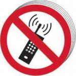 The photo features a pack of 10 self-adhesive vinyl prohibited signs from Spectrum Industrial. Each sign shows a No Mobile Phones symbol and measures 50mm in diameter. The signs are ideal for workplace use to enforce mobile phone restrictions.