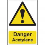 The photograph captures a Spectrum Industrial Danger Sign displaying the words Danger Acetylene in bold black text on a vibrant yellow background. The sign is made of 1.2mm thick recyclable PP material and measures 200 x 300mm. It serves as a clear warning of potential danger in an industrial environment.