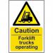 The picture shows a rectangular industrial sign with a yellow background and bold black font stating Caution Fork Lift Trucks Operating. The sign is made of self-adhesive vinyl and measures 200mm by 300mm. In the top left corner is the logo for Spectrum Industrial.