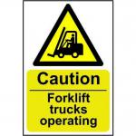 The photograph shows Spectrum Industrial Caution Signs with a bright yellow background and bold black text. The signs read Caution Forklift Trucks Operating in a large font, with smaller text underneath stating the material used (1.2mm Recyclable PP) and the size (200 x 300mm). The signs are rectangular with rounded corners and have a durable, waterproof finish.
