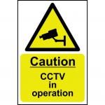 The photo shows a bright yellow Spectrum Industrial CCTV Sign with the words Caution CCTV in operation in bold black letters. The sign is made of 1.2mm recyclable PP, measuring 200 x 300mm. It serves as a warning for the presence of CCTV surveillance in the area.