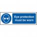The photo captures a bright yellow industrial PPE sign from Spectrum, featuring bold black lettering that reads Eye Protection Must Be Worn. The self-adhesive vinyl material makes it easy to place on any surface, and the compact size of 300mm x 100mm ensures visibility in any workspace.
