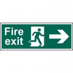 The photograph showcases a bright red industrial fire safety sign with the words Fire exit and a man-shaped arrow pointing right. Made from 1.2mm recyclable PP material, the sign measures 600mm x 200mm and bears the number 12003.