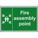 The photograph features a bright and bold fire safety sign from Spectrum Industrial. Made from 1.2mm recyclable PP, the sign displays a clear image of a fire assembly point, measuring 200 x 300mm. Its design is eye-catching and sure to catch the attention of those passing by.