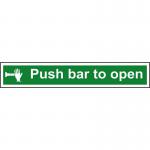 The photo shows a red and white self-adhesive vinyl sign with the words Push Bar To Open in bold letters. The sign is designed for industrial fire safety and measures 600mm x 100mm. A clear image of the push bar symbol is also visible on the sign.