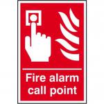 This photograph shows a bright yellow and red fire safety sign with the words Fire Alarm Call Point in bold black letters. The sign is made of self-adhesive vinyl and measures 200mm x 300mm. Behind the text is an image of a red fire alarm call point, emphasizing the emergency nature of the sign. The background of the sign is a dark gray tone, making the text and image stand out clearly.