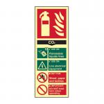The image shows three industrial fire extinguisher signs in the shape of a rectangular label. The sign is made of 1.3mm rigid material with self-adhesive backing. The main text reads FIRE EXTINGUISHER CO2 with a smaller text below indicating it is a photoluminescent sign. The dimensions of the sign are 82mm x 202mm.