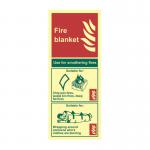 The image shows a bright yellow fire safety sign from Spectrum Industrial. The sign features a graphic of a fire blanket and is made of a 1.3mm rigid material with self adhesive backing. The size is 82mm x 202mm. The sign also glows in the dark thanks to its photoluminescent properties.