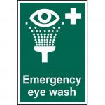 The picture shows a vibrant, eye-catching first aid sign featuring the words Emergency Eye Wash in bold lettering and a white symbol of an eye with water droplets. The sign is made of self-adhesive vinyl and measures 200mm x 300mm. Its striking colors and clear design make it easily visible and recognizable for quick access during emergencies.