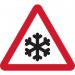 The photo captures a busy industrial road with traffic signs warning of the risk of ice. In the foreground, a temporary road sign with a frame stands tall, displaying a triangular shape and cautionary message. Surrounding buildings and vehicles can be seen in the background.