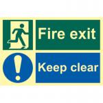 This image shows a Spectrum Industrial Fire Safety Signs Fire Exit Keep Clear Sign. The sign is made of flexible photoluminescent vinyl and measures 300mm x 200mm. It features a bold, red and white design with clear text and symbols, making it easily visible and legible in an emergency situation. The photoluminescent material means that the sign will remain visible even in low light conditions.