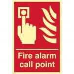 The photograph shows a large, rectangular fire safety sign with the words Fire Alarm Call Point in bold letters. The sign is made of flexible, photoluminescent vinyl material and measures 200mm by 300mm. The background is a bright orange color, and the text and graphics are in white and black. In the center, there is an illustration of a fire alarm call point button with a finger pressing it. The sign is designed for industrial use and can be easily seen in low light conditions.