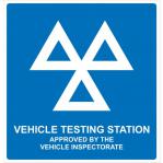 The photograph features a view of Spectrum Industrial Road, with vibrant traffic signs located on the side. In the foreground, a MOT vehicle testing station stands tall, made from 1.2mm recyclable PP material. The dimensions are 625 x 600mm and the station is numbered 18500.