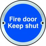 The photograph shows a Spectrum Industrial Room Signs Fire Door Keep Shut Door Disc in SAA color with a diameter of 75mm. The fire door is prominently displayed, with clear instructions and warning signs in easy-to-read text. The sleek design and sturdy construction of the sign can be seen, making it a valuable addition to any industrial setting.