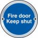 A shiny, circular, metal sign with bold white letters reading Fire Door Keep Shut against a spectrum of colorful stripes. Perfect for industrial settings and fire safety regulations.