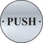 The picture shows a round, satin anodised aluminium door disc with the words Spectrum Industrial Room Signs and Push engraved on it. The disc has a diameter of 75mm and is mounted on a door. Simple and professional in design, this door sign is ideal for industrial spaces.