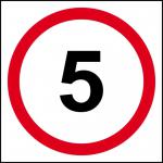 The picture shows a Spectrum Industrial road with a 5mph speed limit sign on a 3mm Foamex board measuring 400mm x 400mm. Traffic signs line the road, giving direction and warning to drivers. The bright and bold colors of the signs stand out against the grey background.