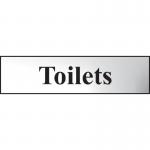 The photograph shows a sleek and modern-looking Spectrum Industrial Washroom Signs Toilets Sign. It features a chrome effect and is made of self-adhesive PVC, measuring 200mm x 50mm. The sign is perfect for any industrial or commercial restroom setting with its clean design and easy installation.