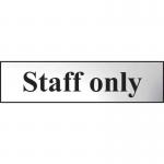 The photograph shows a sleek Spectrum Industrial Room Signs Staff Only Sign. It is chrome effect and made of self-adhesive PVC. This rectangular sign measures 200mm x 50mm and is perfect for professional or industrial spaces. Its bold lettering and sharp edges are easy to read and stand out.