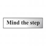 The Spectrum Industrial Room Signs Mind The Step Sign is in chrome effect and made of self-adhesive PVC. It measures 200mm by 50mm. The sign has a bold print displaying the words Mind The Step in white against a black background, with a bright orange caution symbol. The chrome effect gives the sign a sleek and modern look, while the self-adhesive PVC makes it easy to apply on any smooth surface. The sign serves as a clear warning for potential hazards in industrial settings.