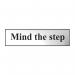 The Spectrum Industrial Room Signs Mind The Step Sign is in chrome effect and made of self-adhesive PVC. It measures 200mm by 50mm. The sign has a bold print displaying the words Mind The Step in white against a black background, with a bright orange caution symbol. The chrome effect gives the sign a sleek and modern look, while the self-adhesive PVC makes it easy to apply on any smooth surface. The sign serves as a clear warning for potential hazards in industrial settings.