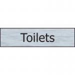 The image shows a sleek Spectrum Industrial Washroom Signs Toilets Sign, made of stainless steel material with a self-adhesive back. It measures 200mm x 50mm, making it the perfect size for any bathroom. The silver finish gives off a modern and professional look, while the bold font makes it easy to read and understand. This sign is durable and easy to install, making it a great addition to any washroom setting.