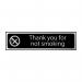 This photograph captures a sleek and modern Spectrum Industrial No Smoking Sign in black and polished chrome effect. The sign features the words Thank You For Not Smoking in bold white font against a black background. Measuring 200mm by 50mm, it is made of self-adhesive PVC for easy installation.