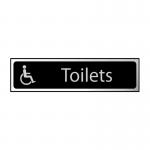 The photo shows a black and polished chrome effect Spectrum Industrial Washroom Sign for toilets with a Disabled Logo on self-adhesive PVC material. The sign measures 200mm x 50mm and is suitable for industrial washrooms.