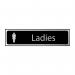 The photograph shows a sleek and modern Spectrum Industrial Washroom Sign for ladies. The sign features a black and polished chrome effect, giving it a stylish and professional look. Made from self-adhesive PVC, the sign measures 200mm x 50mm.