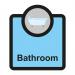 The image shows a light-colored rectangular sign with the words Assisted Living Sign: Bathroom in bold black lettering. The sign has a blue and white Spectrum Industrial Room Signs logo in the upper right corner. The dimensions of the sign are 266 x 310mm.