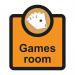 In this photograph, we see a Spectrum Industrial Room Sign for an Assisted Living facility. The sign reads Games Room - SA FMX in bold white letters against a blue background. The sign measures 266 x 310mm and has the product code ALS069 printed on the bottom.