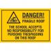 The photograph shows a Spectrum Industrial Safety Signs Educational Sign with a bold red border and the words Danger. Fragile Roof in white capital letters. The sign also states that the school holds no liability for trespassers on the roof. The sign measures 400 x 300mm and has the code EDU020 printed on it.