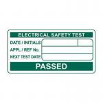 The photo features a roll of 500 small, rectangular labels with a size of 50 x 25mm. The labels are white with black text that reads PASSED Electrical safety test and Spectrum Industrial Miscellaneous Labels. The labels are organized neatly on a roll and appear to be ready for use.