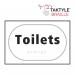 The photograph shows a Spectrum Industrial washroom sign for toilets, with a self-adhesive taktyle design in white. The sign measures 225mm by 150mm and is labeled TK2030BKWH.