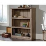The photo shows a sturdy Teknik Office Barrister Home 3 Shelf Bookcase in a beautiful Salt Oak finish. It features two adjustable shelves and easy assembly. The clean lines and classic design make it a perfect addition to any home or office space.